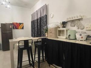 a kitchen with a counter with stools and a microwave at RUANG by ZD in Pekan +6 photos