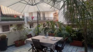 a table and chairs with an umbrella in a courtyard at Casa Luce in Milazzo