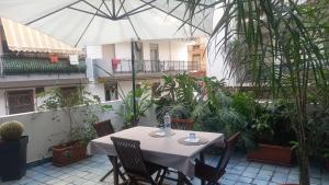 a table and chairs with an umbrella in a courtyard at Casa Luce in Milazzo +20 photos