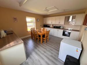a kitchen with a table and chairs in a room at Clohanbeg School House in Kilrush