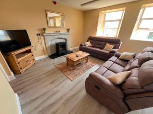 a living room with a couch and a fireplace at Clohanbeg School House in Kilrush
