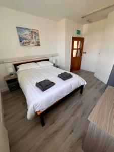 a bedroom with a large bed with white sheets at Clohanbeg School House in Kilrush