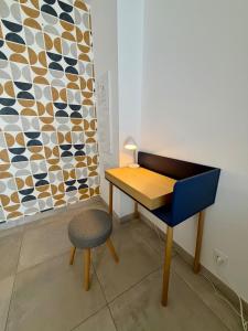 a desk and a chair next to a wall at Le Marronnier - Studio confortable proche de Lyon in Charbonnières-les-Bains