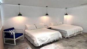 a bedroom with two beds and a chair and lights at 南灣飯店 Kenting Nanwan Hotel in Nanwan