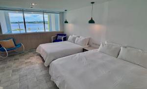 a hotel room with two beds and a window at 南灣飯店 Kenting Nanwan Hotel in Nanwan