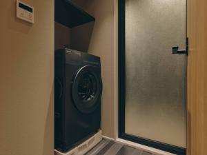 a washing machine in a hallway next to a door at illi Sen Oshiage in Tokyo