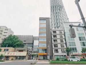a tall building with a tower in the background at illi Sen Oshiage in Tokyo