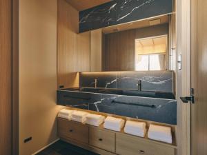 a bathroom with a sink and a mirror at illi Sen Oshiage in Tokyo