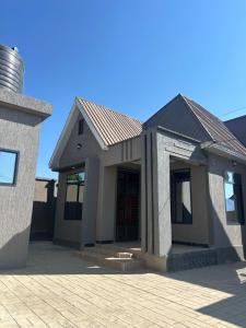 a house with a brick driveway in front of it at Vn mbeya apartment in Mbeya