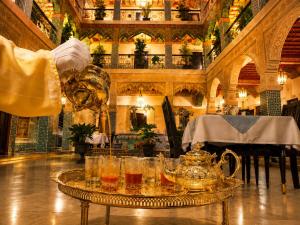 Palais Riad Reda & Spa في فاس: طاولة عليها أكواب وغلاية شاي في غرفة