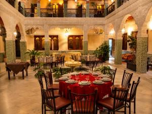 a dining room with a red table and chairs at Palais Riad Reda & Spa in Fez
