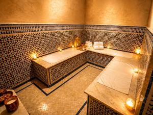 a bathroom with a tub with candles in it at Palais Riad Reda & Spa in Fez +97 photos