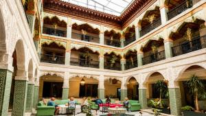 a group of people sitting at tables in a building at Palais Riad Reda & Spa in Fez