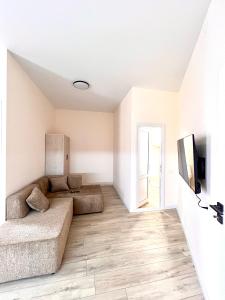 a living room with a couch and a tv at Hayrapetyan Guest House in Yeghegnadzor