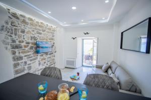 a living room with a table and a stone wall at Caelum Et Mare in Donja Lastva