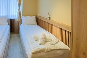 two beds in a room with towels on them at FourMountains-Trebević in Sarajevo