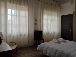 a bedroom with a bed and a television and a window at Il Ginepro del Campidano in Nuraminis