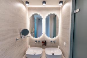 a bathroom with a toilet and three mirrors at Kefalos View in Vrachonisída Palaiókastro +16 photos