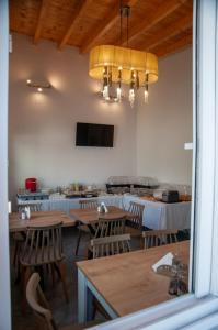 a dining room with tables and chairs and a television at GLIPTIS Apartments in Chios