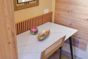 a white table with two bowls of flowers on it at FourMountains-Trebević in Sarajevo