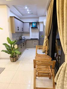 a kitchen with two chairs and a table and a kitchen with at Royale Rest Suites in Rāmkot