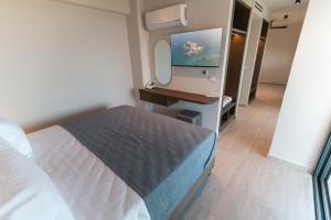 a small bedroom with a bed and a tv at Kefalos View in Vrachonisída Palaiókastro