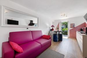 a living room with a purple couch and a kitchen at Il Roncaccio Residence Colico in Colico