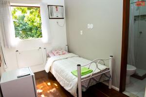 a small bedroom with a bed and a window at Orange - Casa de Hóspedes - modelo Pousada in Rio de Janeiro