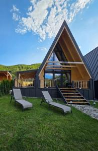 a group of chairs sitting on the grass in front of a house at REIA A-frame in Gura Râului