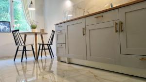 a kitchen with a table and chairs and a counter at Teodor Apartment in Budraičiai