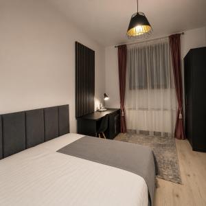 a bedroom with a bed and a desk and a lamp at ARINI WHITE HOUSE in Sibiu