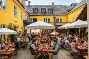 a group of people sitting at tables in an outdoor restaurant at Hotel Gasthof Post in Nesselwang