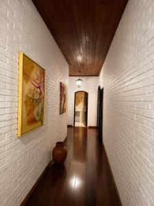 a hallway with a white brick wall with a vase on it at Pousada Sítio das Cerejeiras in São Roque