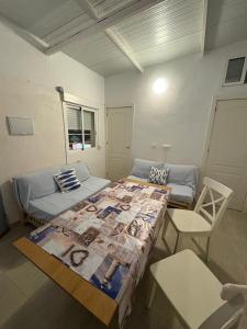 a room with two beds and a table and a chair at El Gachero in Puerto de Mazarrón