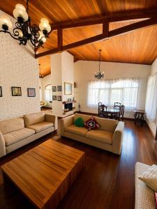 a large living room with two couches and a table at Pousada Sítio das Cerejeiras in São Roque