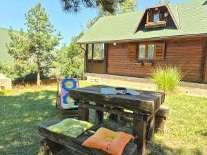a wooden table and a chair in front of a house at Kraljeva breza in Divčibare