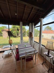 a dining room with a table and chairs and windows at Villa Azkanean in Bidart