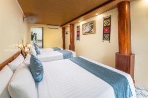 a bedroom with two beds with blue pillows at Catba Papillon Garden Bungalows & Resort in Cat Ba