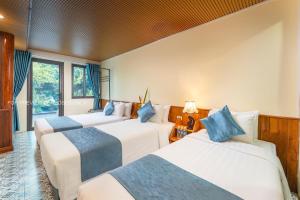 a group of three beds in a room at Catba Papillon Garden Bungalows & Resort in Cat Ba +101 photos