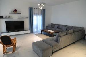 a living room with a large couch and a television at Located in a quiet area ! in Durrës