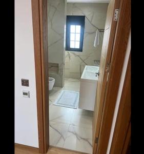 a bathroom with a sink and a toilet and a window at Located in a quiet area ! in Durrës +7 photos