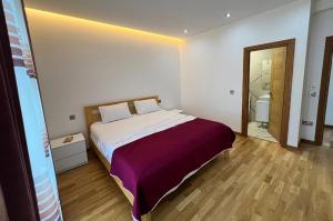 a bedroom with a large bed and a bathroom at Located in a quiet area ! in Durrës