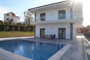 a white house with a swimming pool in front of it at Located in a quiet area ! in Durrës