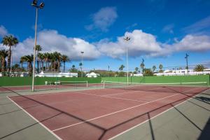 a tennis court with palm trees in the background at Ona Las Brisas in Playa Blanca