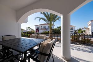 a black table and chairs on a patio with a palm tree at Carrington Holidays in Kyrenia