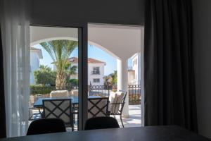 a room with a view of a patio with a table and chairs at Carrington Holidays in Kyrenia