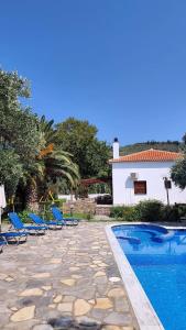 a villa with a swimming pool and blue lounge chairs at Razi Beach in Lefokastro +102 photos