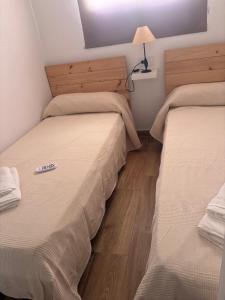 two beds in a room with a lamp on a table at La casa del papica in Níjar +5 photos