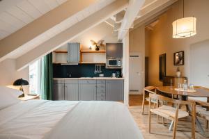 a bedroom with a bed and a table and a kitchen at MANA LISA Boutiquehotel in Lauda-Königshofen