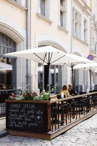 two people sitting at an outdoor table with umbrellas at Neiburgs Hotel in Riga